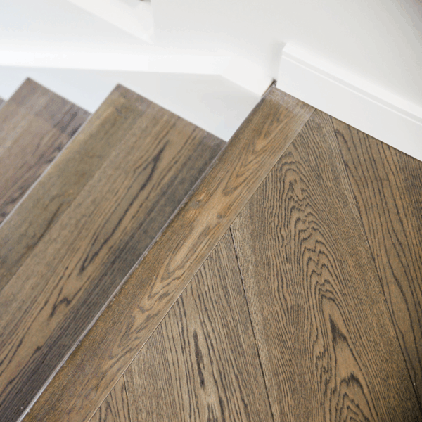 Close-up view of a wooden staircase with herringbone pattern flooring